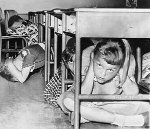 Children hiding under their desk when told to duck and cover.